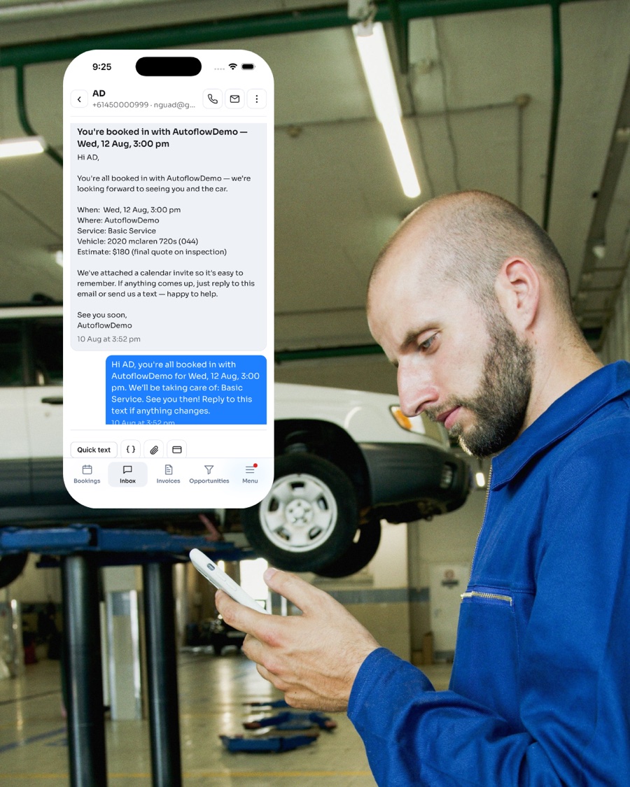 A mechanic in a workshop checking a booking confirmation on his phone in the AutoFlow app
